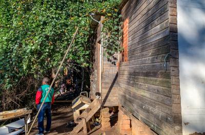 Moradias de área de risco de Porto Alegre em ação de reassentamento, com técnico do Demhab ao fundo, de costas