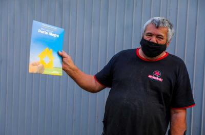 Morador mostra pastinha azul com o tÃtulo de propriedade