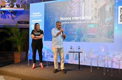 Prefeito Melo e Letícia Batistela em cima de um palco no evento