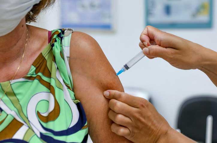 Idosa recebendo vacina no braço esquerdo